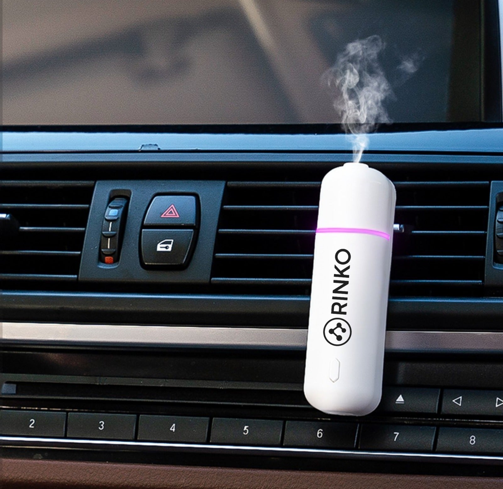 RINKO car air freshener diffusing mist on dashboard, sleek white design with purple glow