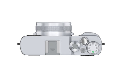 Silver compact camera with top controls and mode dial for versatile shooting